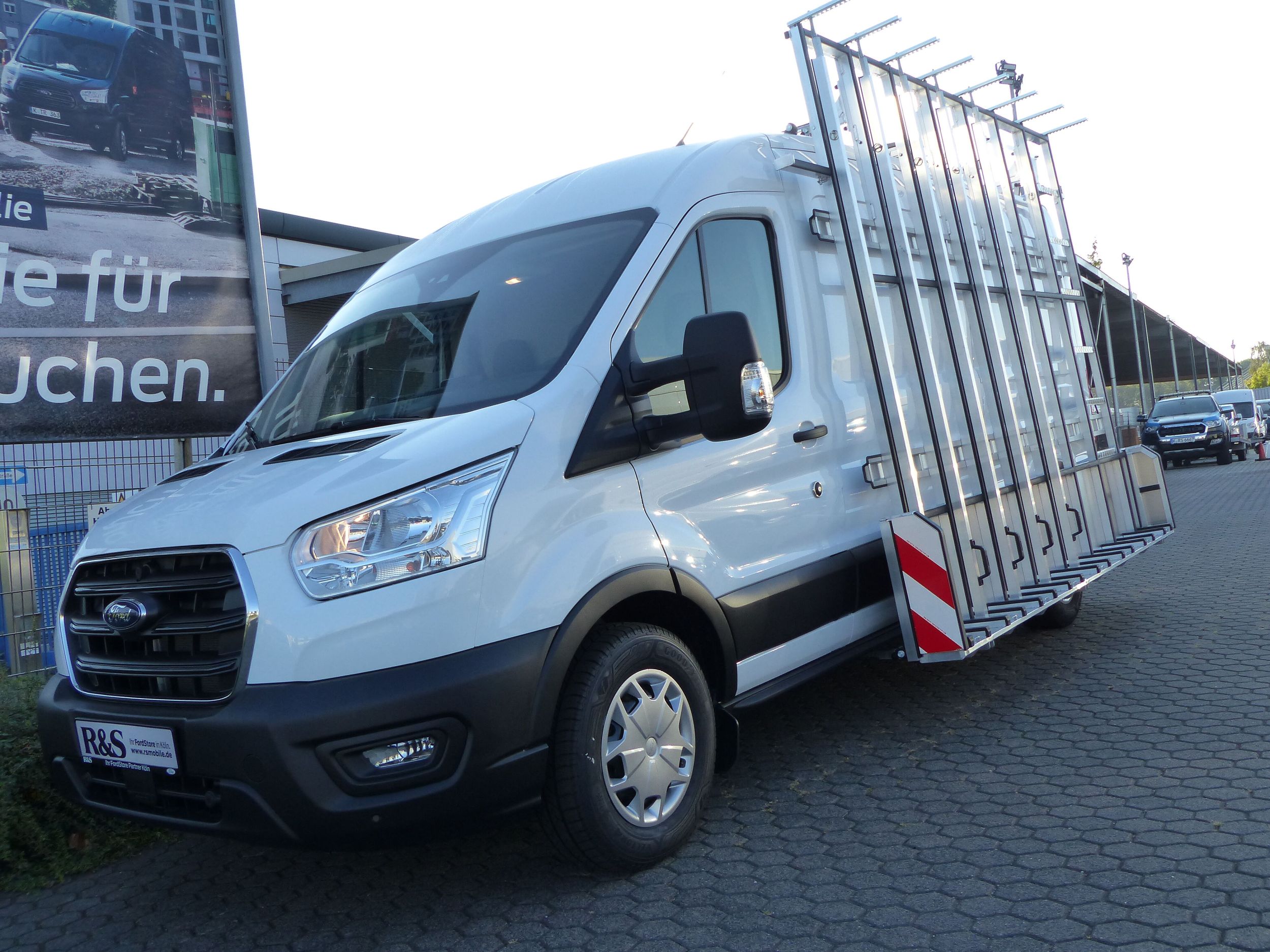 Der Ford Transit mit einer Glasrack-Konstruktion seitlich von vorne gezeigt
