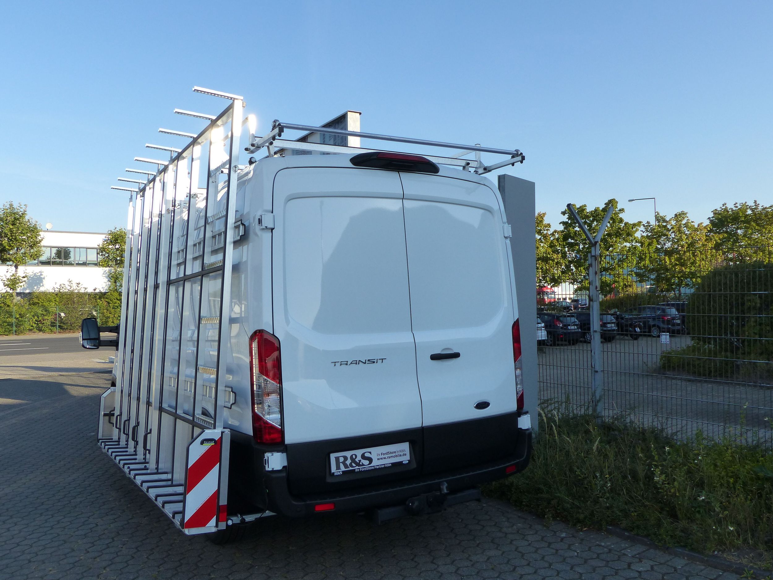 Der Ford Transit mit einer Glasrack-Konstruktion von hinten gezeigt