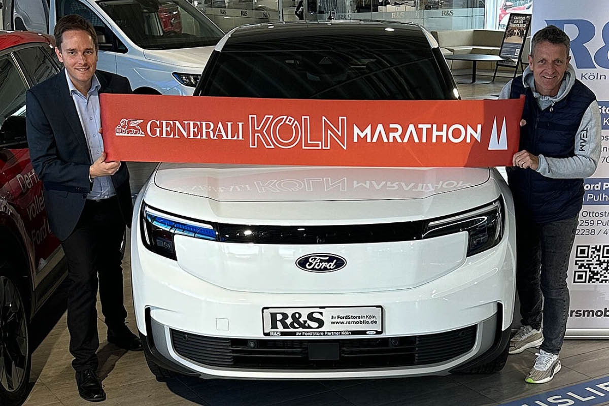 Ford E-Tourneo Courier vor den 2 Personen ein Banner des Köln-Marathons halten