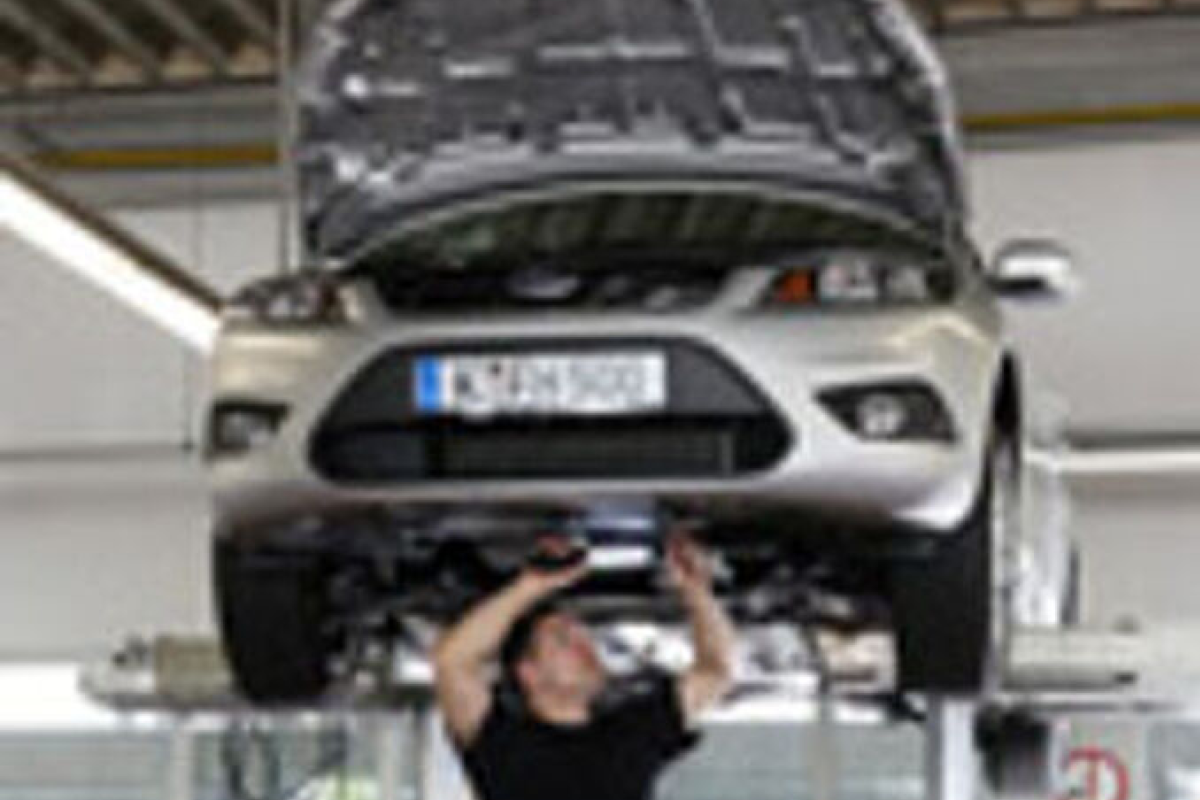 Eine person führt Arbeiten an einem Fahrzeug in der Werkstatt durch