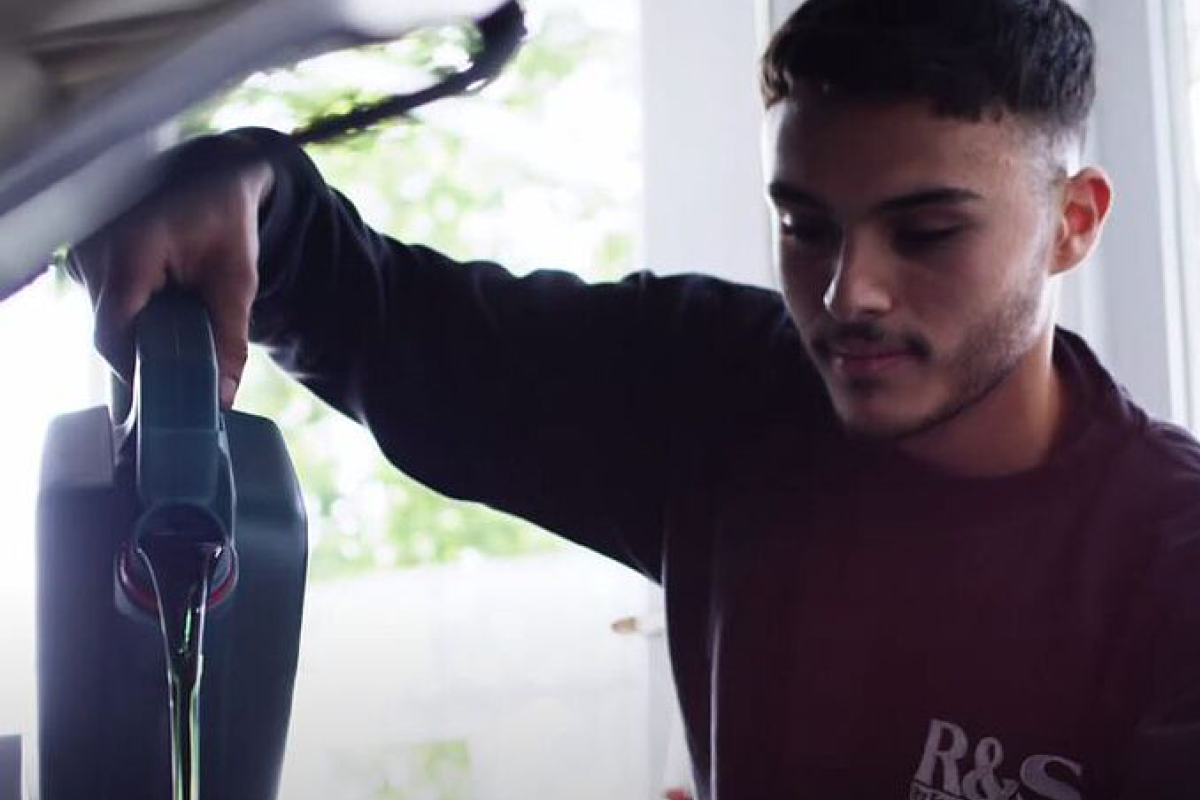 Ein Mitarbeiter füllt Motoröl in das Fahrzeug