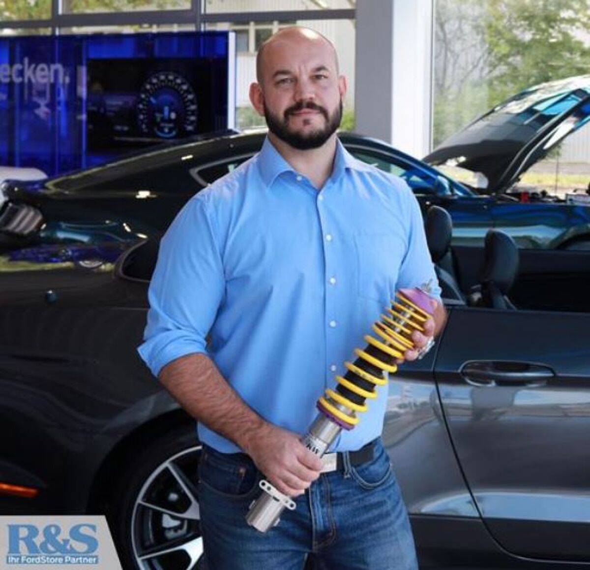 Eine Person hält eine Fahrzeug-Feder in der Hand
